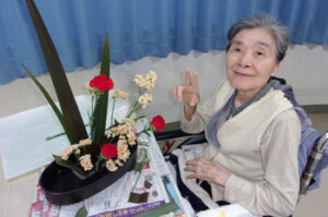 居住者が花を活ける活動をしている様子。生花アレンジメント体験の風景。